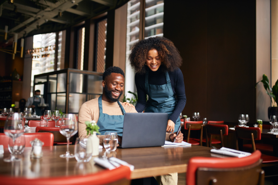 man and woman checking on their restaurant's website on computer