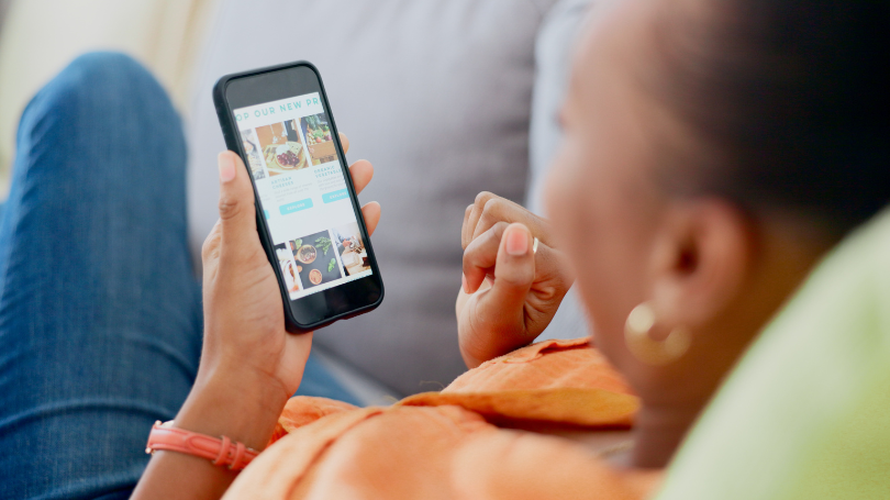 woman checking a mobile website design on her phone