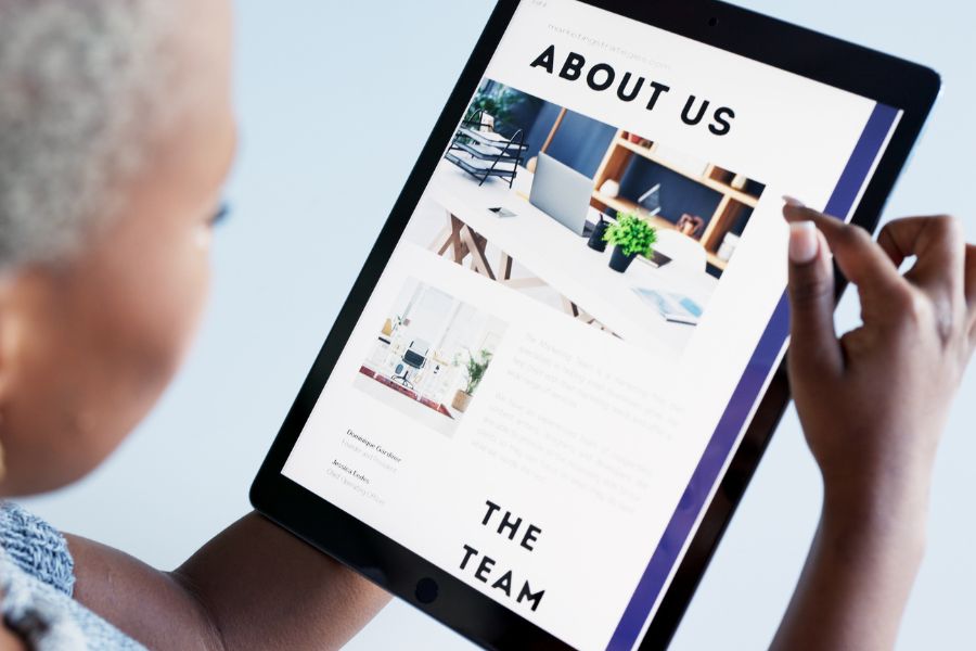 A person looking at the "About Us" page of a website on a tablet.