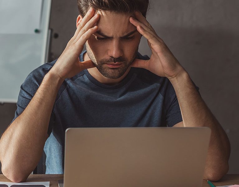 worried-man-working-on-ui-design-at-desk